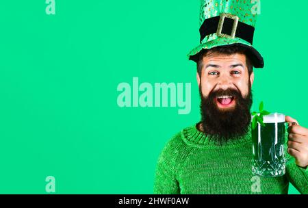 Festa di Patricks. Uomo portato in cappello leprechaun con birra verde. Tradizione irlandese. Foto Stock