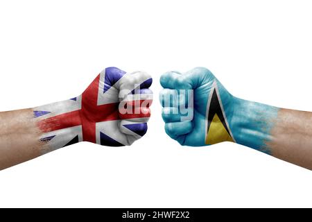 Due mani si pugno l'una all'altra su sfondo bianco. Bandiere di campagna dipinte pugni, conflitto concetto di crisi tra gran bretagna e santa lucia Foto Stock
