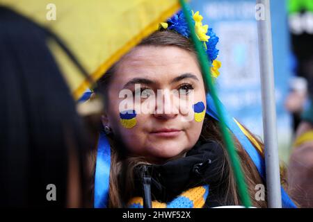 New York, Stati Uniti. 5 marzo 2022 - New York City, New York, unisce gli stati: Un protestore indossa i colori della bandiera Ucraina sulle guance durante una dimostrazione contro l'invasione russa dell'Ucraina in un raduno a Times Square di New York City questo pomeriggio. Foto Stock