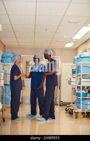 parlare di medicare. Sparo completo del personale medico in un ospedale. Foto Stock