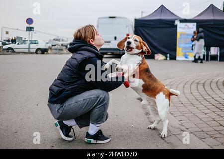 La ragazza Ucraina è vista giocare con il suo cane mentre attende un trasporto dalla zona di attraversamento di frontiera. Attraversamento di frontiera polacco-ucraino a Medyka. Dall'inizio dell'invasione russa dell'Ucraina, circa 700.000 persone sono fuggite in Polonia per sfuggire alla guerra. Nonostante la disinformazione considerevole e gli incidenti isolati, i rifugiati ucraini sono accolti con empatia, aiuto e comprensione, ma molti esperti umanitari indicano che, con un afflusso così enorme di persone, una crisi potrebbe verificarsi in poche settimane. Foto Stock