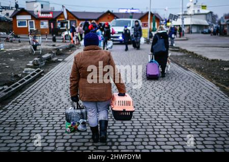 Medyka, Subcarpathia, Polonia. 3rd Mar 2022. Donna Ucraina che fugge dalla guerra si vede portare una scatola con un animale domestico alla zona di frontiera, molti rifugiati evacuano dalla zona di guerra con i loro animali domestici.Polacco-ucraino frontiera a Medyka. Dall'inizio dell'invasione russa dell'Ucraina, circa 700.000 persone sono fuggite in Polonia per sfuggire alla guerra. Nonostante la disinformazione considerevole e gli incidenti isolati, i rifugiati ucraini sono accolti con empatia, aiuto e comprensione, ma molti esperti umanitari indicano che con un afflusso così enorme di persone, una crisi potrebbe verificarsi io Foto Stock