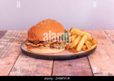 La carne di pollo tritata viene mescolata con erbe aromatiche e poi ricoperta di farina, uova e pangrattato per renderla molto croccante. Ha anche rucola, brie Foto Stock