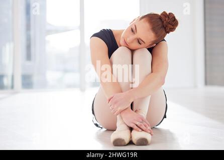 La concorrenza è stata serrata. Scatto di una ballerina che ha un aspetto triste mentre si siede nel suo studio di danza. Foto Stock