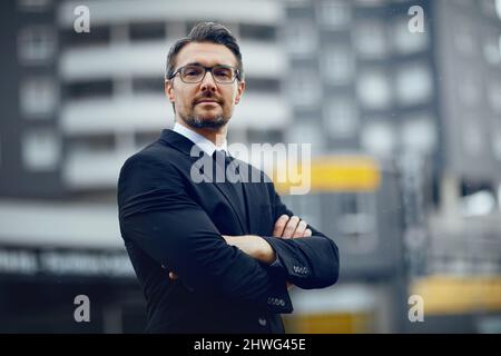 Mantenendo le sue ambizioni grandi come la città. Ritratto di un uomo d'affari maturo in piedi in città. Foto Stock