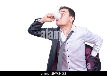 Hurying uomo d'affari che beve il caffè mentre mette sulla giacca Foto Stock