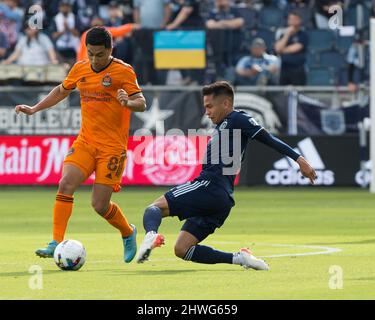 Kansas City, Kansas, Stati Uniti. 4th Mar 2022. Il centrocampista sportivo Felipe Hernandez #21 (r) scivola in un tackle contro il centrocampista di Houston Dynamo Memo Rodriguez #8 (l) durante la prima metà del gioco. (Credit Image: © Serena S.Y. Filo pressa Hsu/ZUMA) Foto Stock