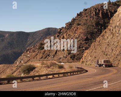 US 60 nel centro dell'Arizona mentre scende verso il ponte Salt River Canyon. Un grande rimorchio americano comincia il decent giù la strada tortuosa. Foto Stock