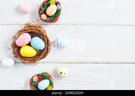 Uova di pasqua coloseful in nido su sfondo rosa con spazio. Concetto minimo. Scheda con spazio per la copia del testo. Foto Stock
