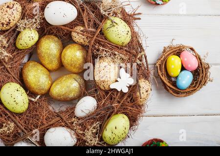 Uova di pasqua coloseful in nido su sfondo rosa con spazio. Concetto minimo. Scheda con spazio per la copia del testo. Foto Stock