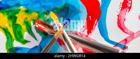 Arte e tema artigianale che mostra alcuni pennelli incrociati su terra colorata acquerello Foto Stock