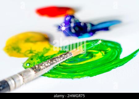 Arte brillante e tema artigianale che mostra un pennello e qualche vernice colorata nella parte posteriore chiara Foto Stock