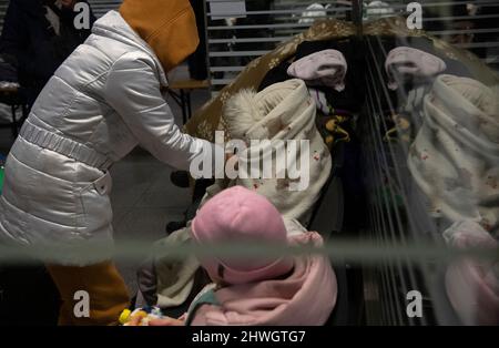 Berlino, Germania. 06th Mar 2022. Una donna ucraina avvolge un bambino in una coperta riscaldata alla stazione ferroviaria principale di Berlino. Anche questa mattina sono già arrivati a Berlino numerosi rifugiati provenienti dalla zona di guerra. Le truppe russe invasero l'Ucraina il 24 febbraio. Credit: Paul Zinken/dpa/Alamy Live News Foto Stock