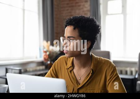 Donna d'affari seria che indossa gli occhiali, seduto sul posto di lavoro dell'ufficio Foto Stock