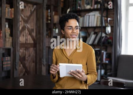 Pensieroso positivo Black gadget utente donna perso nei pensieri Foto Stock