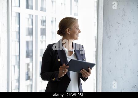 Felice uomo d'affari di mezza età 40s in possesso di tablet digitale. Foto Stock