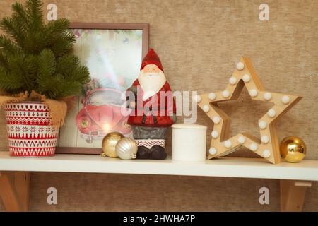 Decorazioni di Natale. Stella di legno e figurine di babbo natale e abeto decorativo in una pentola Foto Stock