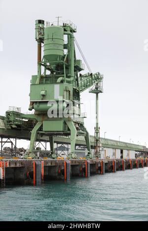 La gru bulk verde si trova nel porto. Attrezzatura di trasporto del grano del porto islandese Foto Stock