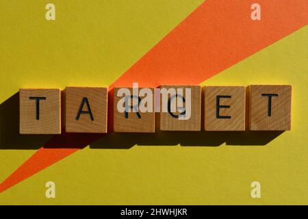 Bersaglio, parola in lettere di legno dell'alfabeto isolato su sfondo luminoso e colorato Foto Stock