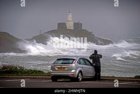 Le enormi onde si infrangono nella Mumbles Lighhouse sulla penisola di Gower, vicino a Swansea, in acqua alta, questa mattina, mentre la costa del Galles del Sud sente tutta la forza di Storm Eunice. Foto Stock