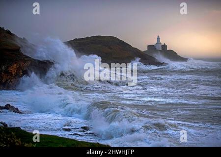 Le enormi onde si infrangono nella Mumbles Lighhouse sulla penisola di Gower, vicino a Swansea, in acqua alta, questa mattina, mentre la costa del Galles del Sud sente tutta la forza di Storm Eunice. Foto Stock