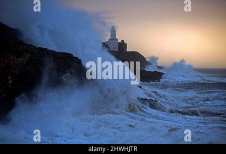 Le enormi onde si infrangono nella Mumbles Lighhouse sulla penisola di Gower, vicino a Swansea, in acqua alta, questa mattina, mentre la costa del Galles del Sud sente tutta la forza di Storm Eunice. Foto Stock
