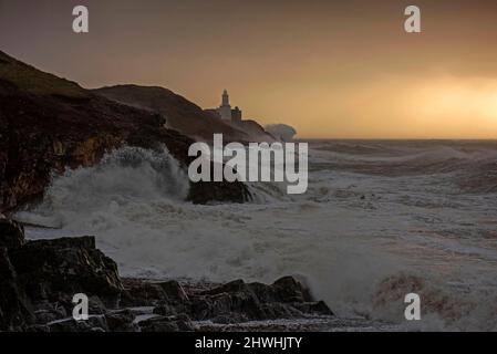 Le enormi onde si infrangono nella Mumbles Lighhouse sulla penisola di Gower, vicino a Swansea, in acqua alta, questa mattina, mentre la costa del Galles del Sud sente tutta la forza di Storm Eunice. Foto Stock