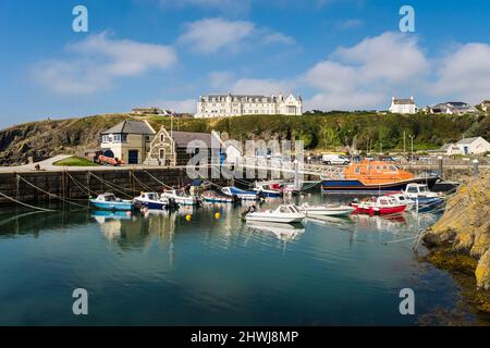 RNLI Lifeboat e piccole barche ormeggiate nel porto naturale nel villaggio di pescatori della costa occidentale. Portpatrick, Dumfries e Galloway, Scozia, Regno Unito, Gran Bretagna, EUR Foto Stock