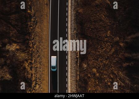 Giro in minibus sull'autostrada. Moderno furgone bianco per la consegna di piccoli carichi, guidando sull'autostrada al sobborgo urbano su strada dipinta fresco. Servizio espresso per la distribuzione e la logistica aziendale Foto Stock