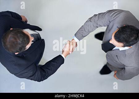 Lascia agitare su di esso. Vista ad angolo di due uomini d'affari che scuotono le mani. Foto Stock