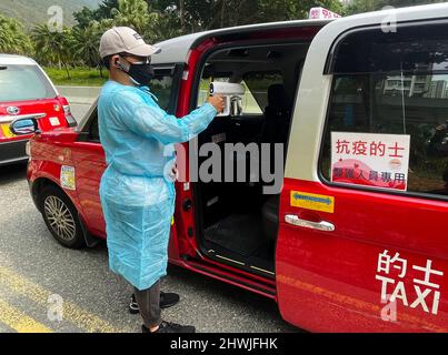 Hong Kong. 6th Mar 2022. Un tassista della flotta 'taxi antiepidemico' disinfetta il suo veicolo a Hong Kong, Cina meridionale, 5 marzo 2022. PER ANDARE CON 'caratteristica: I tassisti di Hong Kong si uniscono COVID-19 Battle' Credit: Xinhua/Alamy Live News Foto Stock