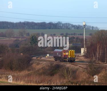 DB Schenker classe 08 locomotiva da shunting 08703 che trasporta un unico carro da carbone HTA che passa sulla linea principale passando per Burton Salmon Foto Stock