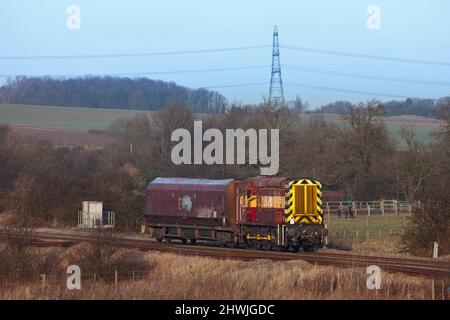 DB Schenker classe 08 locomotiva da shunting 08703 che trasporta un unico carro da carbone HTA che passa sulla linea principale passando per Burton Salmon Foto Stock