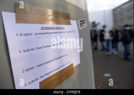 06 marzo 2022, Amburgo: '1st step: Al centro di prova in casa n° 72' è scritto su un pezzo di carta accanto ai rifugiati in attesa presso il centro di arrivo Rahlstedt in tedesco e ucraino. Centinaia di rifugiati ucraini hanno raggiunto Amburgo nel fine settimana. Venerdì e sabato, circa 700 - 750 rifugiati sono arrivati al centro di arrivo a Rahlstedt, ha detto un portavoce del Ministero degli interni. Poiché il centro di arrivo è molto pieno, la città sta chiedendo ai cercatori di protezione che possono trovare alloggi privati e non hanno bisogno di essere ospitati dalle autorità per contattare il centro per il loro registrat Foto Stock