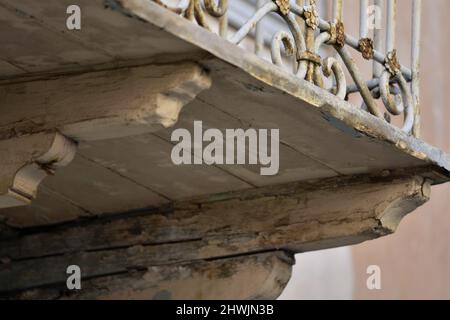 Antica casa neoclassica balcone con ringhiera in ferro battuto arrugginito e supporti in legno a Nafplio, Grecia. Foto Stock