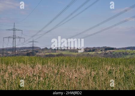 Un polo ad alta tensione con cielo blu bianco Foto Stock