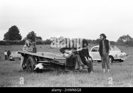 Il Fayre di Glastonbury del 1971, un festival gratuito progettato da Andrew Kerr e Arabella Churchill . Immagini mostra: Gruppo di amici seduti sul retro di un trailer che suona la chitarra e cantano canzoni al festival. 19th giugno 1971. Foto Stock