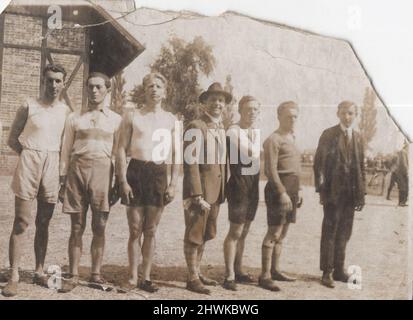 un'antica sopravvivenza ha danneggiato la fotografia monocromatica di sportivi che sono in piedi in linea con loro allenatori al 1900s. Periodo: 1900s, Fonte: Fotografia originale. ULTERIORI-DIRITTI-SPAZIO-INFORMAZIONI-NON-DISPONIBILI Foto Stock