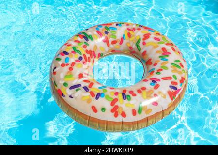 Galleggianti gonfiabili di ciambella circolare nella piscina Foto Stock