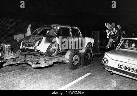 L'auto bruciata trovata a Tilehurst dopo il detective Constable Ian Coward è stato girato nella testa e nel corpo da un uomo che ha saltato fuori da una macchina. Nella foto, tutto ciò che rimane della vettura di fuga del cannoniere, la conchiglia della Austin 1100 essendo trainata via. Si ritiene che il pistolero abbia sparato all'auto di Tilehurst. 27th giugno 1971. Foto Stock