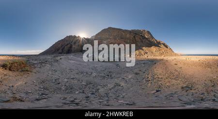 Visualizzazione panoramica a 360 gradi di full senza giunture sferico hdri 360 panorama del tramonto nel deserto con il sole brilla da dietro la montagna sulla costa del mare in progetto equirectangular