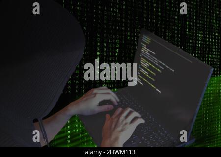 Dark web cyber guerra concetto. Hacker Hooded che utilizza un notebook per organizzare attacchi massicci di violazione dei dati ai server governativi Foto Stock