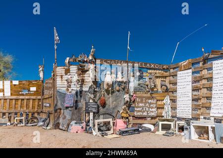 Protesta e ammonimenti sui cartelli sulla recinzione che corrono tra Slab City e East Jesus, due insediamenti off-the-grid sul lato est del sale Foto Stock