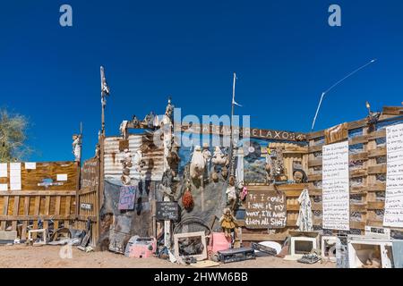 Protesta e ammonimenti sui cartelli sulla recinzione che corrono tra Slab City e East Jesus, due insediamenti off-the-grid sul lato est del sale Foto Stock