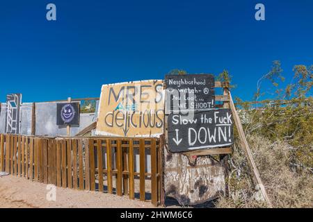 Protesta e ammonimenti sui cartelli sulla recinzione che corrono tra Slab City e East Jesus, due insediamenti off-the-grid sul lato est del sale Foto Stock