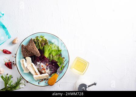 Camambrato, insalata di barbabietole e pane su piatto blu Foto Stock