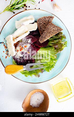 Camambrato, insalata di barbabietole e pane su piatto blu Foto Stock