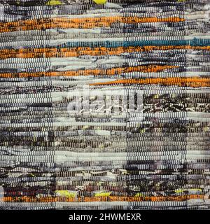 Tappetino per porte realizzato a mano da strisce di tessuto come sfondo. Texture di un tappeto homespun Foto Stock