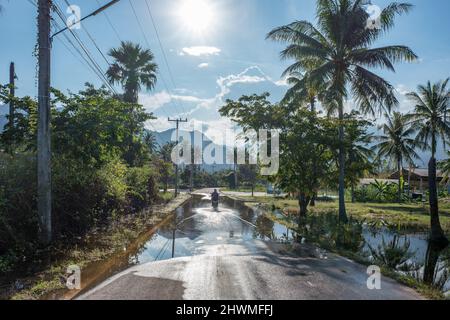 Strada di campagna acqua dopo la pioggia in paesaggio rurale vicino Sam Roi Yot in Thailandia a sud di Hua Hin Foto Stock