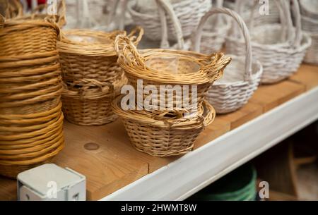 Cestini di vimini sugli scaffali in deposito Foto Stock